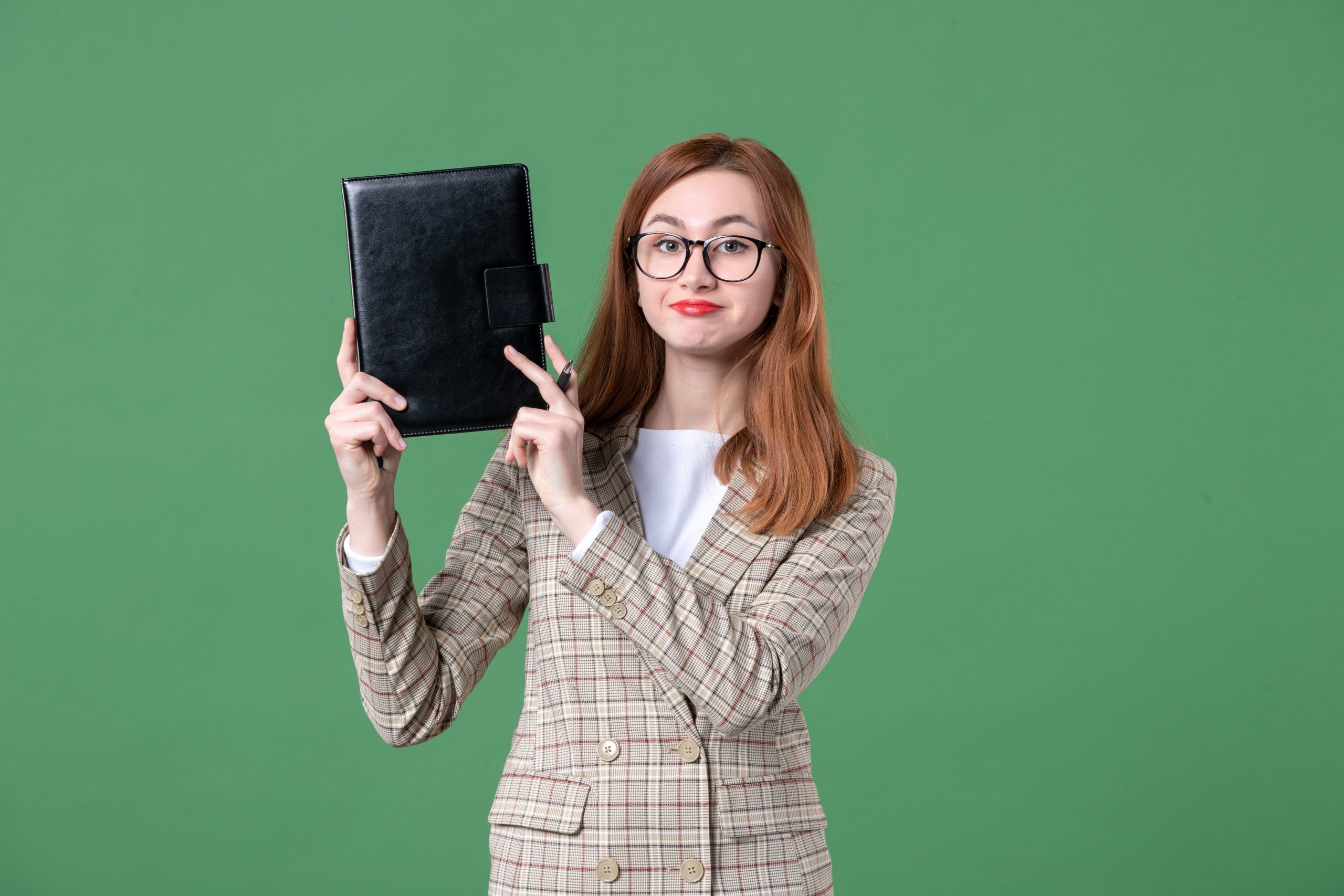 portrait-female-teacher-holding-notepad-green